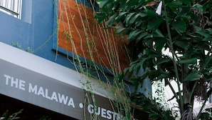 Un edificio con un letrero que dice "THE MALAWA GUEST HOUSE LOVE".
