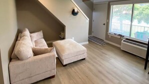 A spacious living room with a high ceiling, a staircase, and a large window providing natural light. - Crescent Bar Condo: On the river with Pool, Gorge shuttle/Wineries, AC (Quincy)