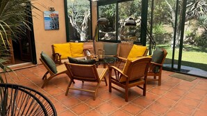 A sunlit patio with wicker furniture, a glass door leading to a garden, and a 'Namaste' sign. - "Villa Mammona 500m from Bonifacio harbour (Bonifacio)