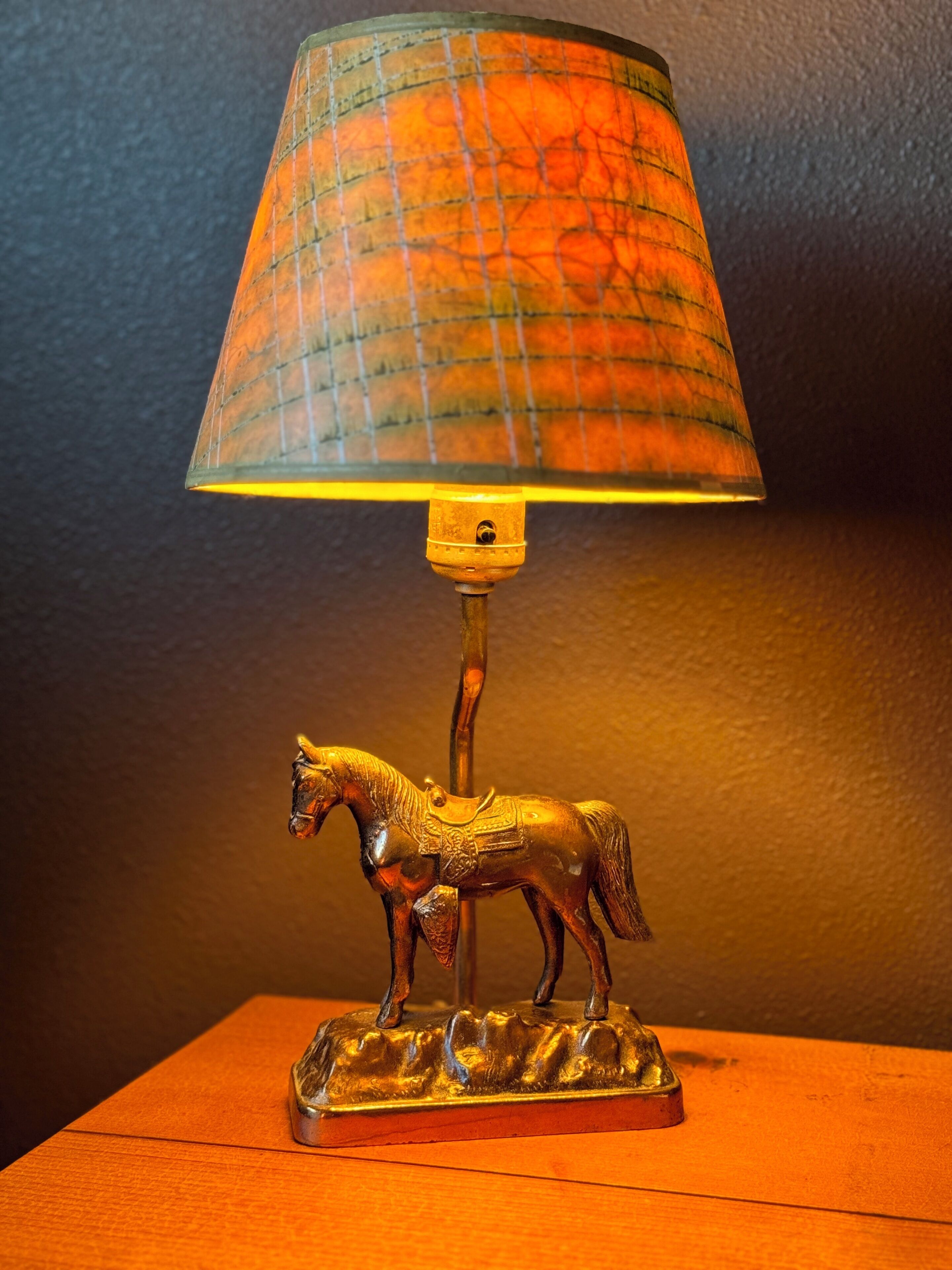 A lamp with a horse-shaped base and a patterned lampshade.