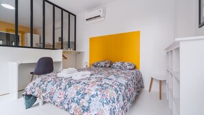 Un dormitorio con cama, escritorio, silla y armario.