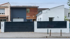 Un edificio residencial moderno con garaje, fachada de madera y exterior blanco.