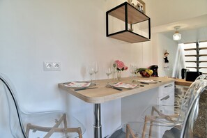 Enjoy meals in a stylish dining area with a wooden table, clear glassware, and comfortable seating.