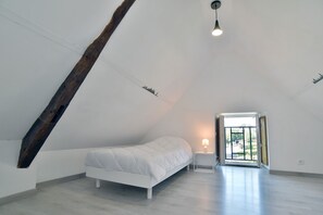 Relax in this stylish room with a neatly made bed, bedside lamp, and access to an outdoor space.