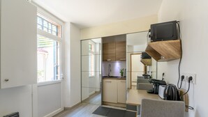 A modern kitchen with a built-in oven, a dining area with a table and chairs, and a small seating area with a sofa. - Cozy Corner - Appt avec jardin pour 4 (Tournan-en-Brie)