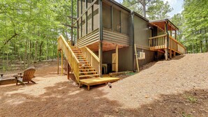 Een chalet met een houten terras, een trap en een picknicktafel.