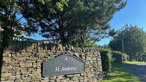 Un muro de piedra con un letrero que dice "St. Andrews".