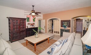 Habitación cuádruple Deluxe, balcón, vistas parciales al mar | Zona de estar