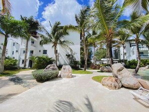 Stroll through the beautifully landscaped grounds, surrounded by palm trees and large rocks, to reach the resort's modern buildings with balconies.