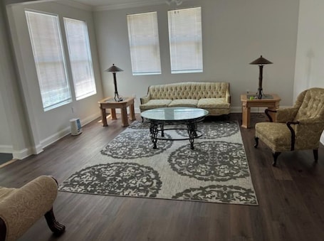 A living room with a round coffee table, beige sofa, patterned rug, and two lamps.