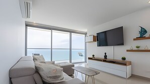 A modern living room with a large window, a flat-screen TV, and a minimalist design. - Awesome Sea View and Historic Center “Morros City” (Cartagena de Indias)