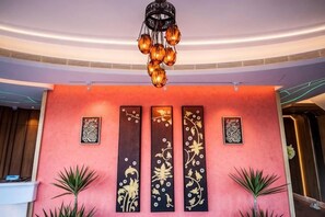 A lobby with a modern chandelier, decorative wall panels, and potted plants. - Dreamer Boutique Hotel (Pingtung)