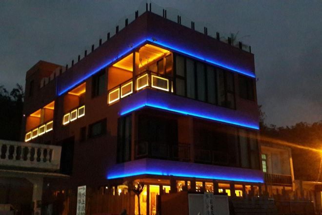 Un immeuble à plusieurs étages, doté d’un toit plat et d’un balcon au deuxième étage.
