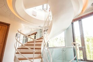 A spiral staircase with a glass railing leading to a higher floor. - Dreamer Boutique Hotel (Pingtung)