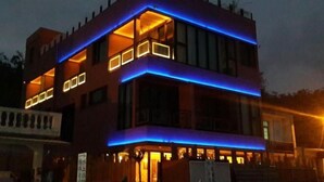 A modern building with a flat roof, multiple windows, and illuminated blue and orange lighting. - Dreamer Boutique Hotel (Pingtung)