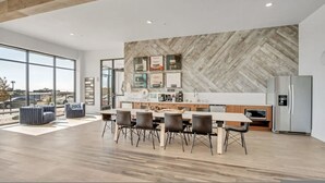 Una cocina moderna con pared de madera en patrón de espiga, una isla grande y un refrigerador.