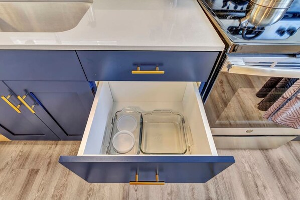 Een keuken met een lade met daarin twee glazen bakvormen.