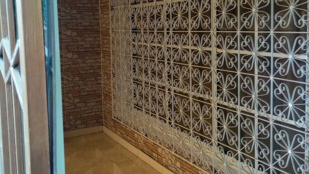 Een kamer met een bakstenen muur en een decoratieve metalen scheiding.