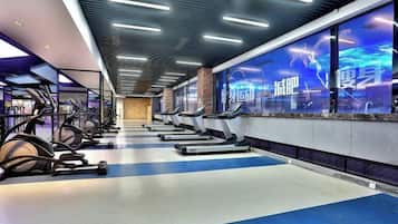 A gym with treadmills, stationary bikes, and weights.