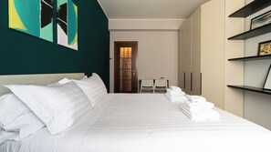 A hotel room with a bed, a desk, and a wardrobe.