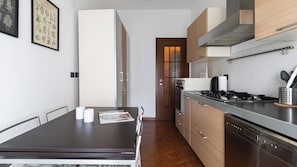 A modern kitchen with a dining table, cabinets, and a stove.