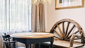 A round table with two woven placemats, a black chair, and a rustic wooden chair with a curved backrest. - Rustic Studio Rain Shower 3min-asian Dist (Oklahoma City)