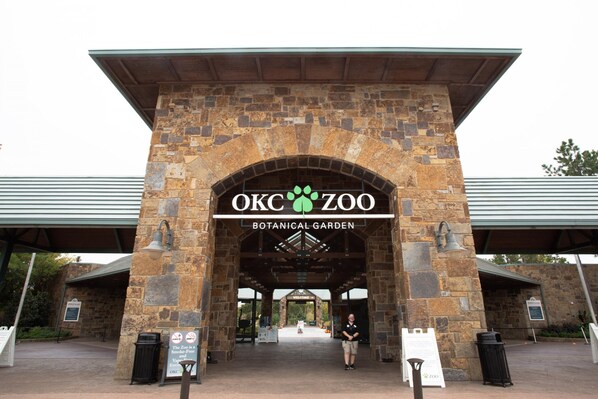 La entrada al Jardín Botánico del zoológico de OKC, con pilares de piedra y un cartel arriba.