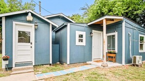 A small, single-story building with a front door, a small porch, and a window.