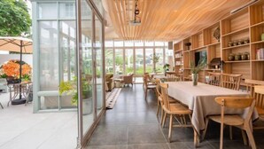 Een moderne eetruimte met houten meubels, glazen wanden en uitzicht op het omliggende landschap.