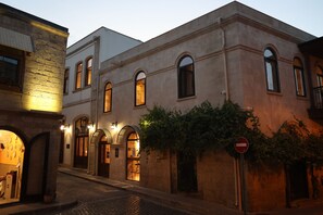 Un bâtiment historique doté d’arcades et situé sur une rue pavée.