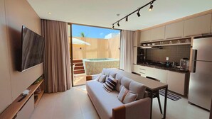 Un apartamento moderno con sala de estar, kitchenette y balcón con hidromasaje.