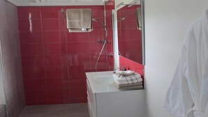 Ein Badezimmer mit roten Fliesen, einem weißen Waschbecken und einem Handtuchhalter.