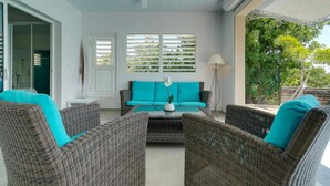 A room with wicker furniture, a teal sofa, and a ceiling fan. - Villa the Lodge - Lagon Saint-françois (Saint-François)
