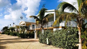 A beachfront hotel with multiple-story buildings, a sandy beach, and palm trees. - 1 Beautiful 4 Bed 3 Bath Pool Home w Free Dock (Marathon)