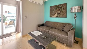 A living room with a sofa, coffee table, and decorative items. - Gorgeous 1 BR PH Apartment w Jacuzzi (Punta Cana)
