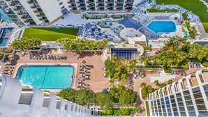 Un hôtel de grande hauteur doté d’une piscine sur le toit, de nombreux balcons et d’un aménagement paysager luxuriant.