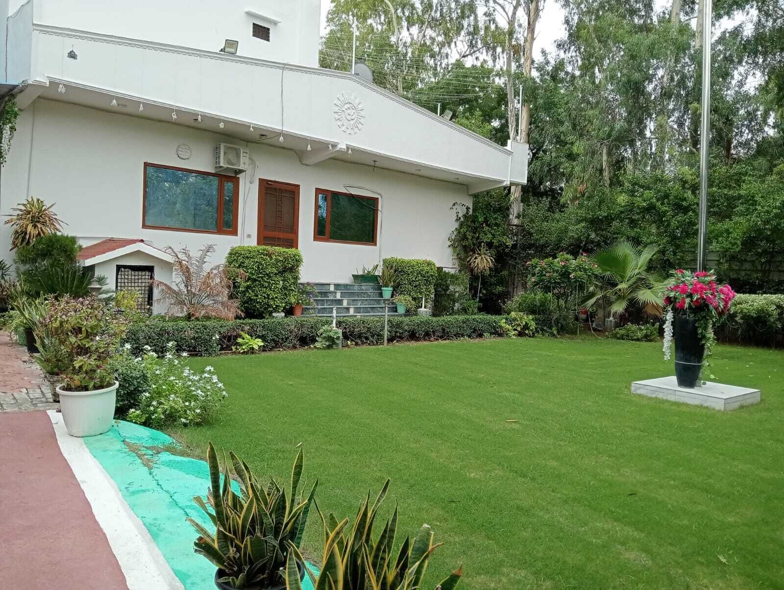 A modern two-story building with a well-maintained lawn and garden.