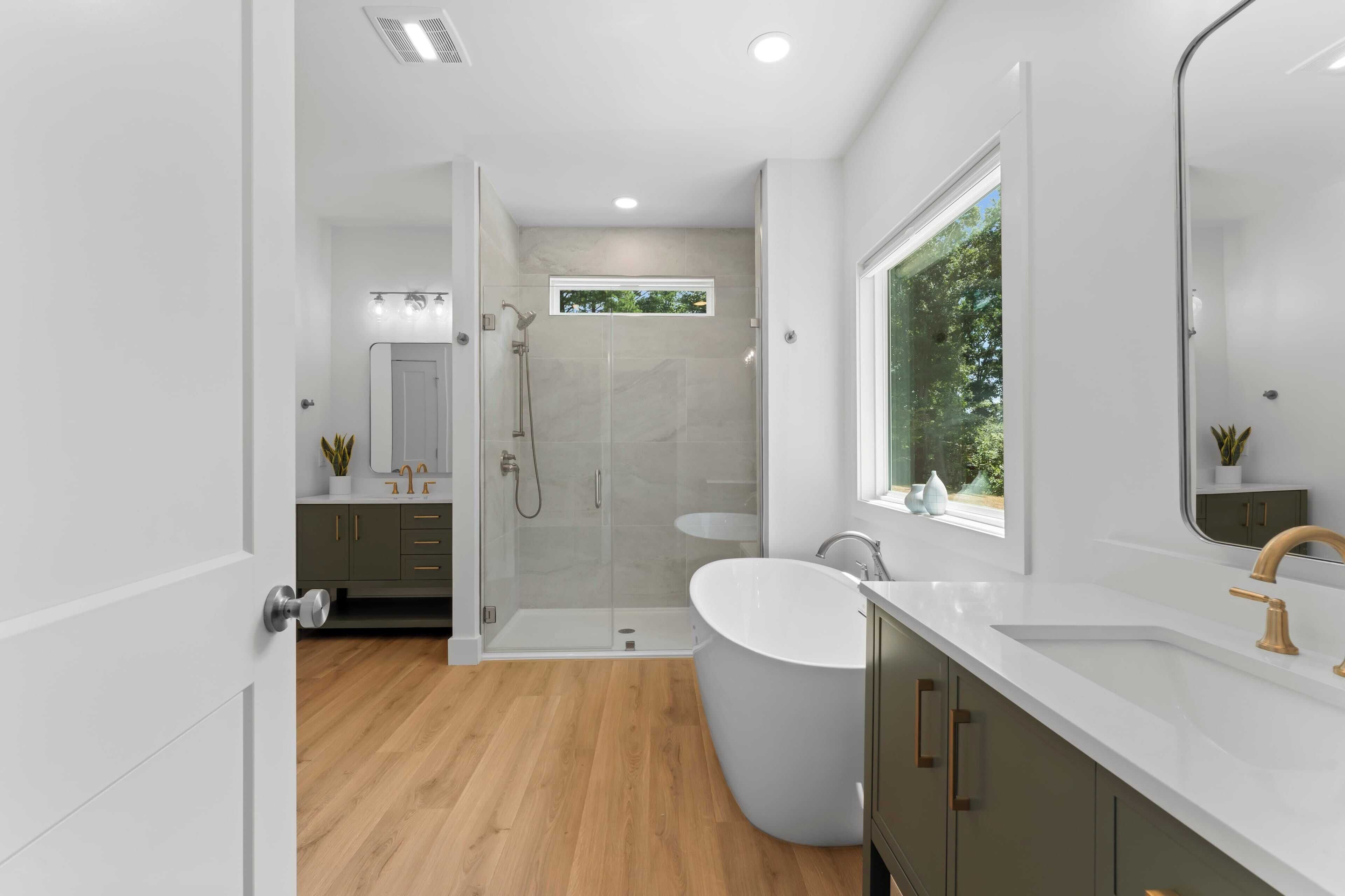 Une salle de bain moderne avec une baignoire sur pieds, une douche à parois de verre et un grand miroir.