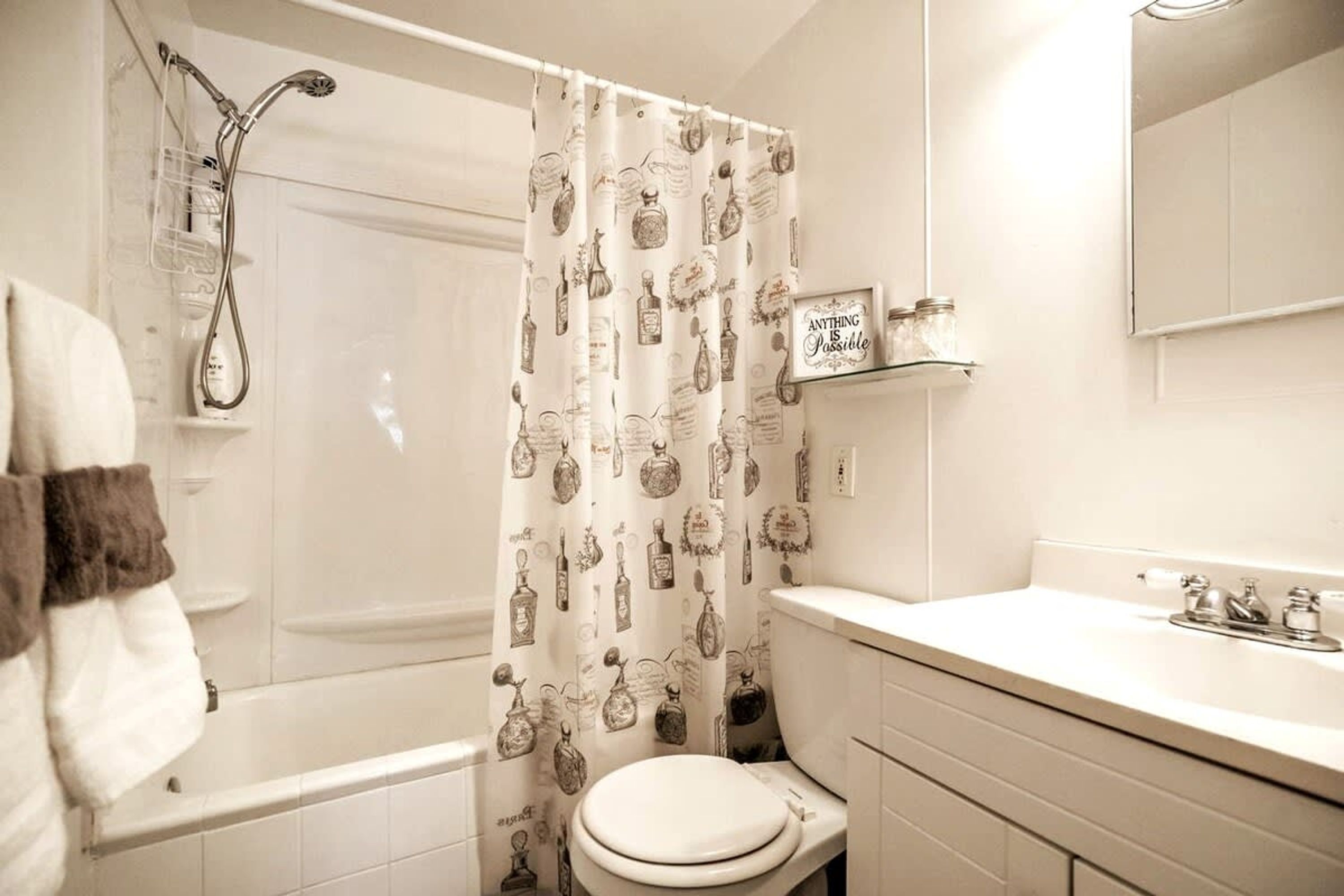A bathroom with a shower, toilet, and sink.