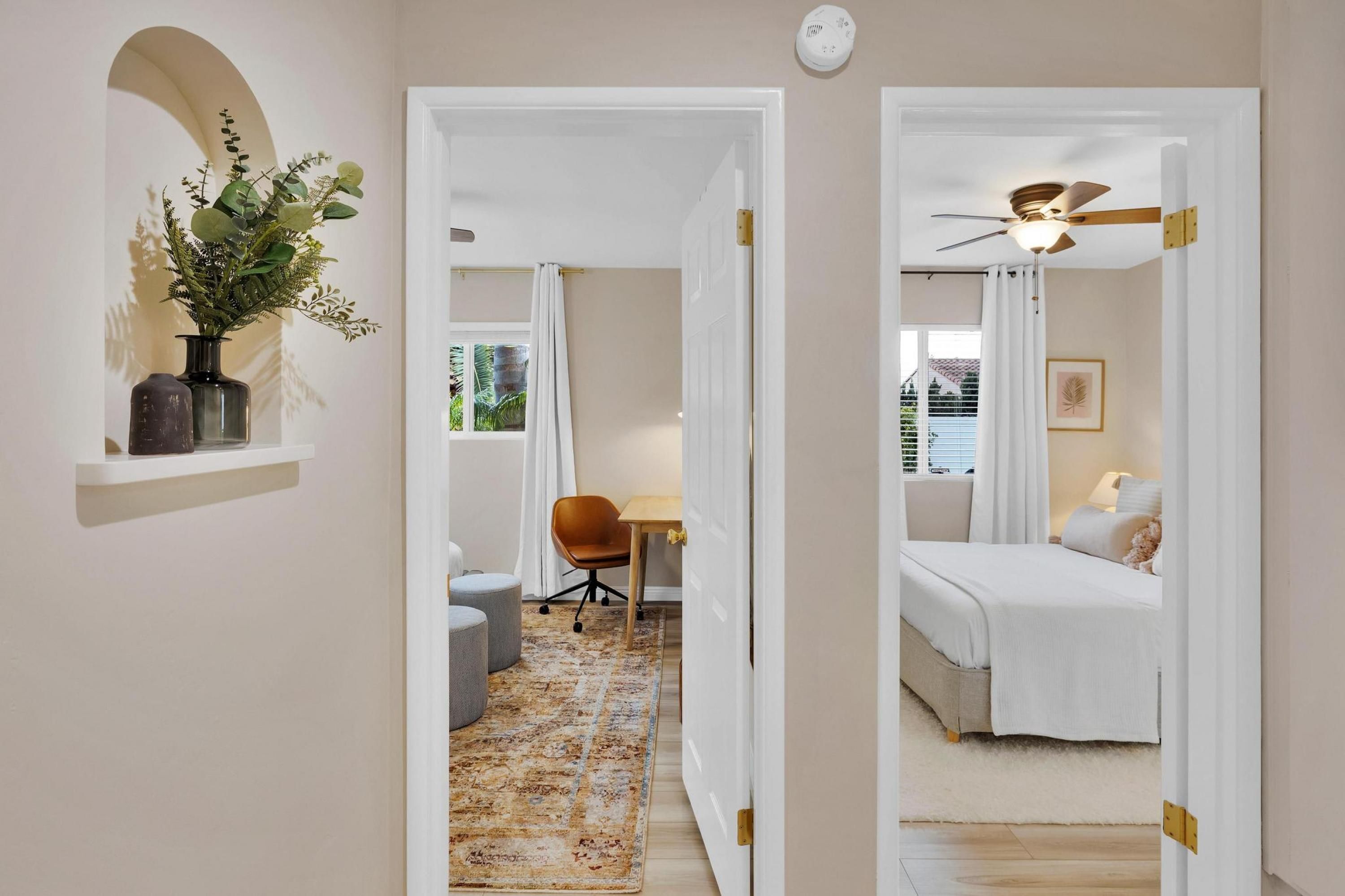 A bedroom with a bed, bedside table, and a ceiling fan.