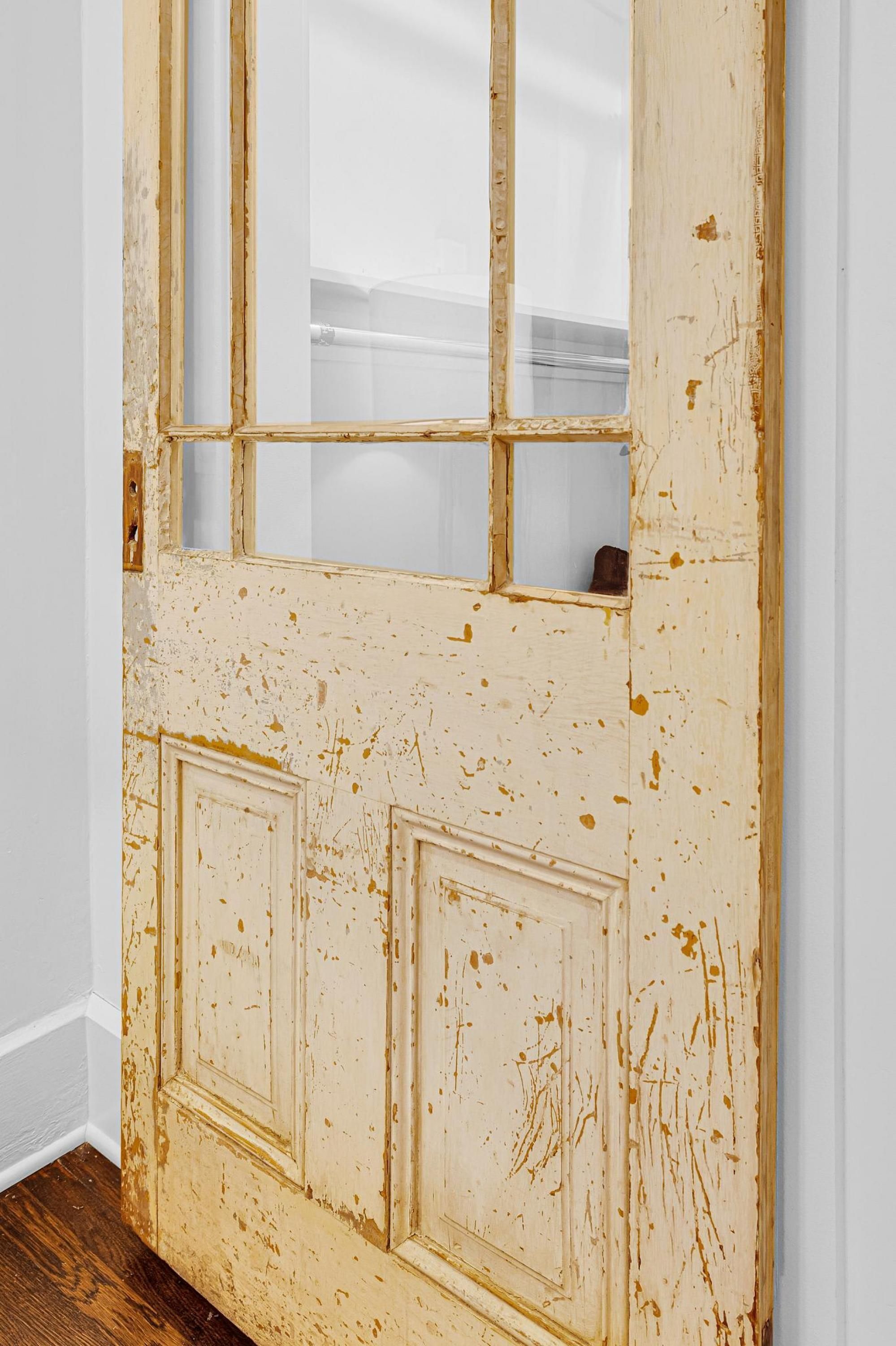 A door with a distressed finish and a window above it.