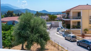 Zona residencial con un edificio que tiene balcones y una calle con coches estacionados.