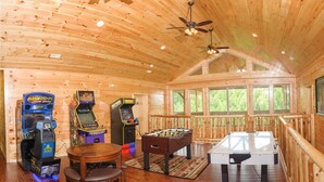 A wooden interior with a foosball table, two arcade machines, and a pool table. - Breathtaking 14br Cabin Elevator Views Games Hot Tubs Galore (Sevierville)