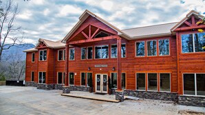 A large wooden building with multiple windows and a stone foundation, labeled 'Sycamore Mansion.' - Breathtaking 14br Cabin Elevator Views Games Hot Tubs Galore (Sevierville)