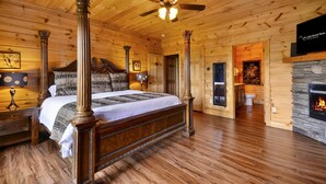 A wooden cabin interior with a four-poster bed, a fireplace, and a ceiling fan. - Gatlinburg s Finest Majestic Views Home Theater Hot Tubs and More (Gatlinburg)