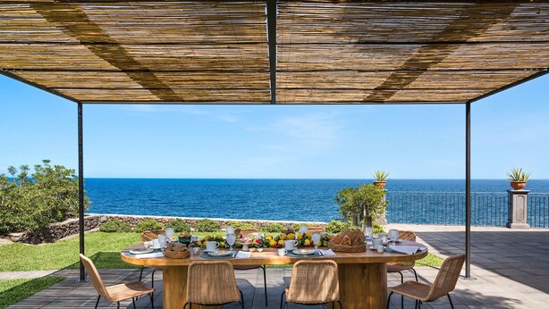 An outdoor dining area with a view of the sea, featuring a wooden table set for four, surrounded by wicker chairs. - Luxury villa with pool and direct access to the sea, Pozzillo (Pozzillo)