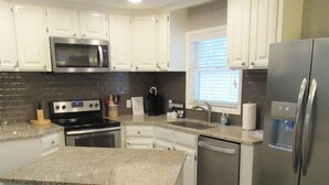 A kitchen with white cabinets, a granite countertop, stainless steel appliances, and a window with blinds. - Lakefront with kayaks and private dock.  Pet friendly, nearby dog park (Hot Springs Village)