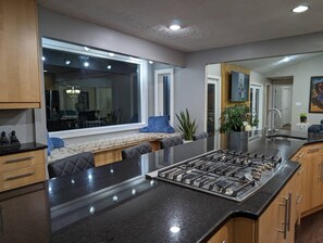 A modern kitchen with a large island, built-in appliances, and a seating area with a view.