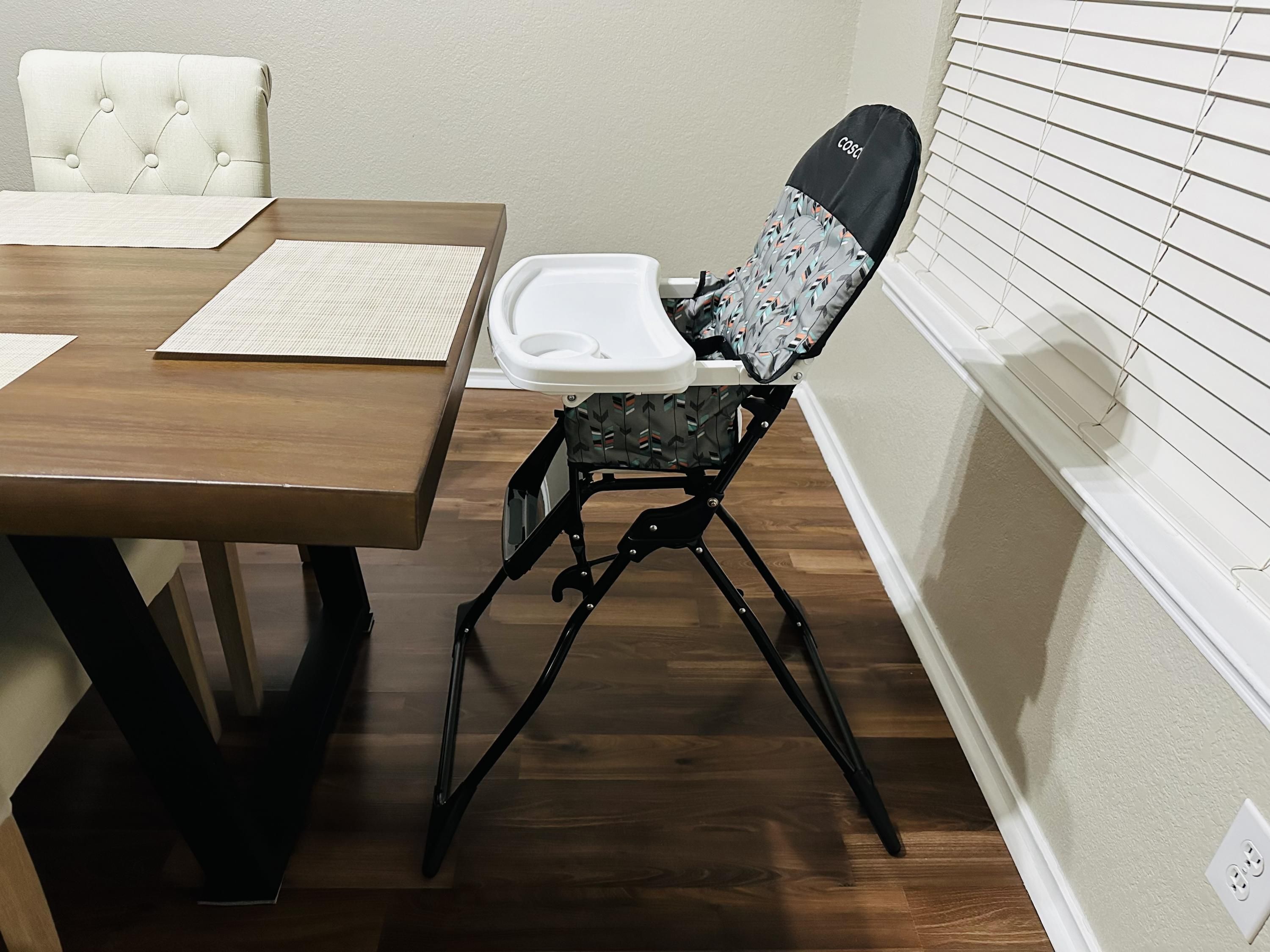 A dining area with a wooden table, a cushioned chair, and a white tray.