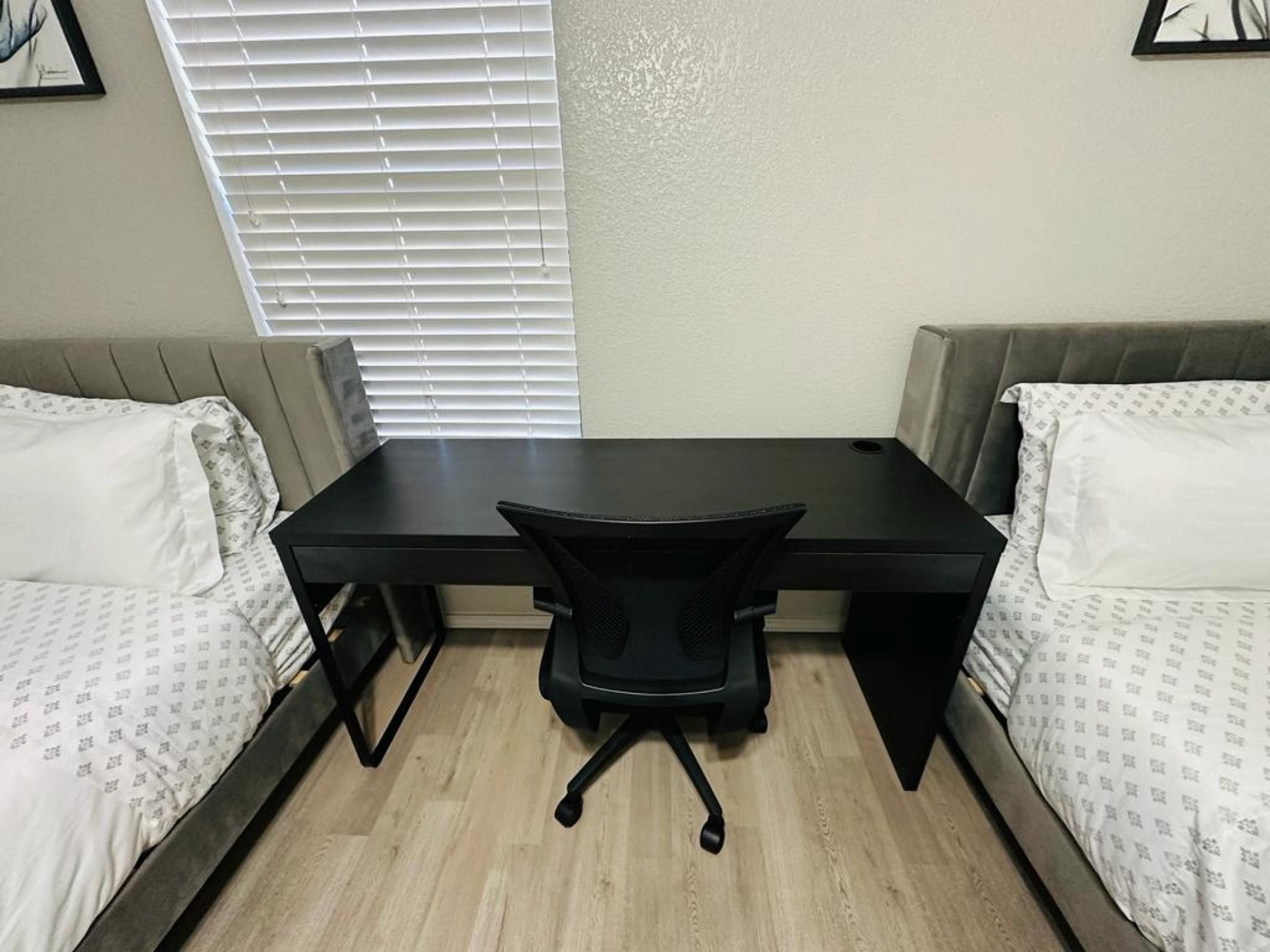 A small room with a desk and two beds.